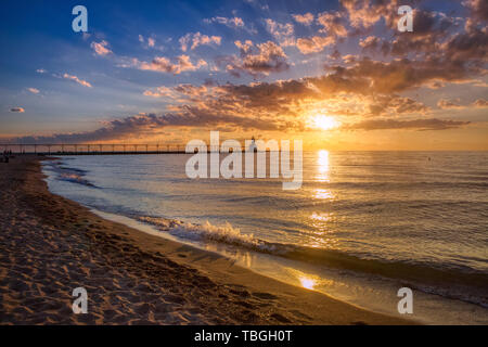 Stunning sunset with dramatic clouds over Michigan City East Pierhead Lighthouse, Washington Park Beach, Michigan City, Indiana Stock Photo