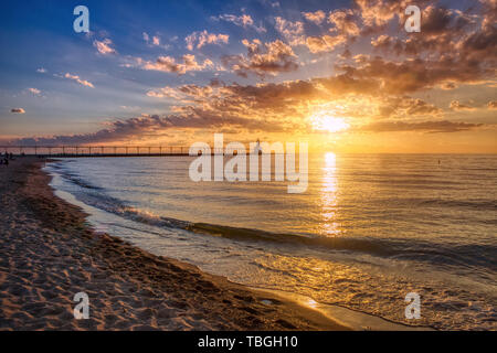 Stunning sunset with dramatic clouds over Michigan City East Pierhead Lighthouse, Washington Park Beach, Michigan City, Indiana Stock Photo