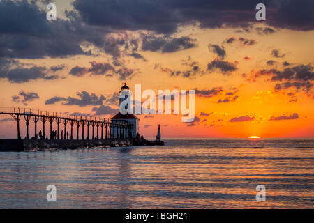 Stunning sunset with dramatic clouds over Michigan City East Pierhead Lighthouse, Washington Park Beach, Michigan City, Indiana Stock Photo