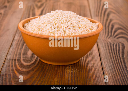 Raw White Rice In A Cup On A Wooden Table Stock Photo Alamy