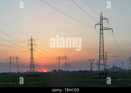 Amazing Sunset view over High-voltage power lines in the land around city of Plovdiv, Bulgaria Stock Photo