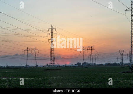 Amazing Sunset view over High-voltage power lines in the land around city of Plovdiv, Bulgaria Stock Photo