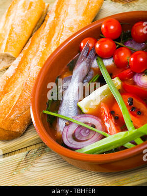 Fisher soup from whiting with tomatoes, red onion, bell pepper served with lemon, scallions, black olives and fresh bread Stock Photo