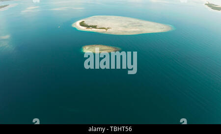 Tropical island and sandy beach with tourists surrounded by coral reef and blue sea in honda bay, aerial view. Island with sand bar and coral reef. starfish island. Summer and travel vacation concept, Philippines, Palawan Stock Photo