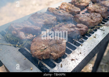 Grilling pork meat with barbecue stuff. Horizontal close up shot with a selective focus. picnic Stock Photo