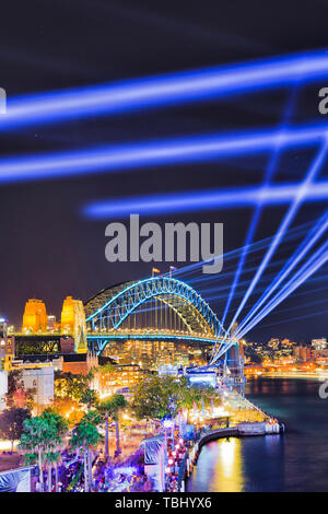 Arch of the Sydney Harbour bridge under blue laser lights of Vivid Sydney ligth show over the Rocks waterfront and Harbour. Stock Photo