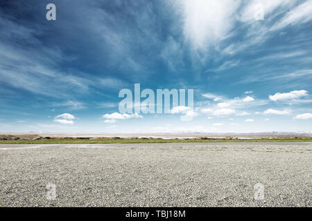 empty dirt floor with snow mountains in blue sky Stock Photo