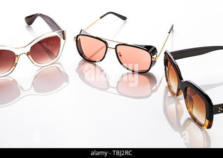 different fashion sunglasses on a white background. on the background you can see the reflection from the glasses Stock Photo