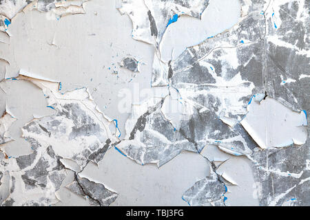Background with the image of the old white wall with falling off and exfoliated paint and plaster on site of the ruins with a chaotic and chaotic text Stock Photo