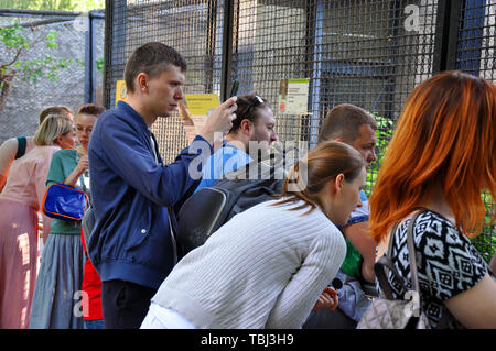 Moscow, Russia - May 25, 2019: a crowd of people take pictures and shoot video from mobile phones and animal devices in the zoo Stock Photo