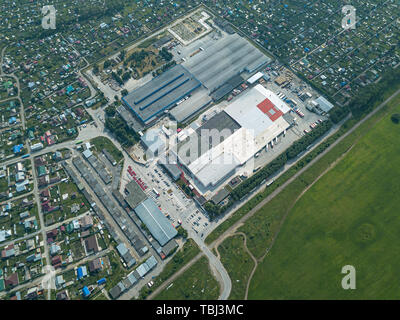 Aerial view of a green agricultural field near the big supermarket and mall in the small town for shopping and buying food and goods by families of pe Stock Photo