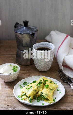 Homemade breakfast of omelet with asparagus and onions and hot coffee. Rustic style, selective focus. Stock Photo
