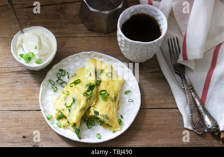 Homemade breakfast of omelet with asparagus and onions and hot coffee. Rustic style, selective focus. Stock Photo