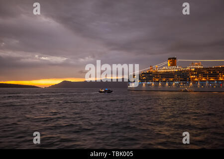 SANTORINI GREECE - OCTOBER 24 2018: Illuminated cruise ship moored in the bay Stock Photo