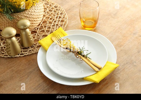 Beautiful table setting with mimosa flowers on wooden background Stock Photo