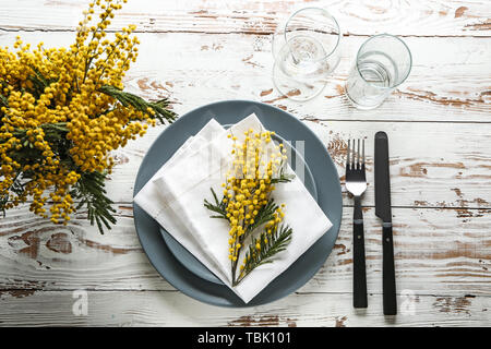 Beautiful table setting with mimosa flowers on wooden background Stock Photo