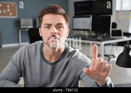 Male programmer using virtual screen in office Stock Photo