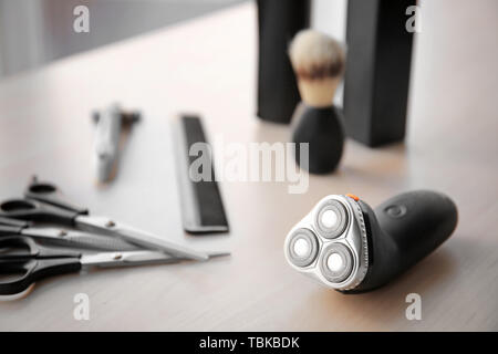 Electric shaver with tools on table Stock Photo