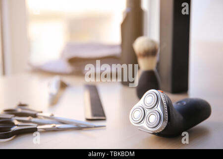 Electric shaver with tools on table Stock Photo
