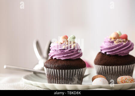 Tasty Easter cupcakes on plate Stock Photo