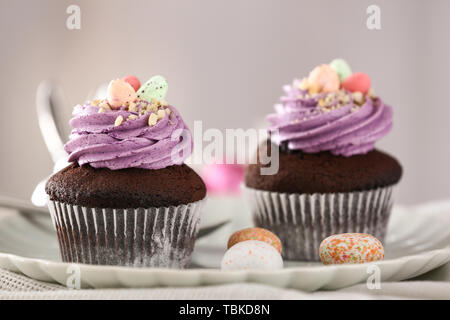 Tasty Easter cupcakes on plate Stock Photo