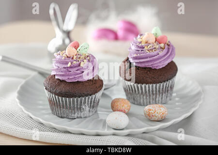 Tasty Easter cupcakes on plate Stock Photo