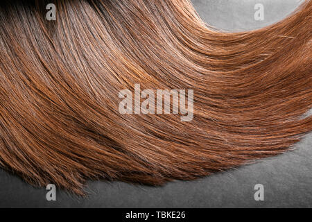 Healthy long female hair on grey background Stock Photo