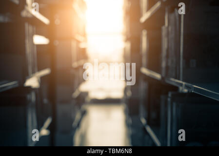 Blurry background of dark library with sunshine at the end. Education and learning concept. Stock Photo