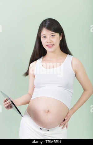 Vertical shot of cute happy european young pregnant woman in