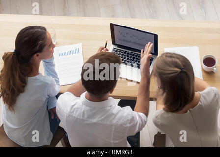 Top view businesswomen and businessman having conversation at laptop Stock Photo