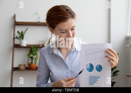 Young employee giving presentation showing financial report looking at charts Stock Photo
