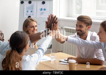 Happy motivated diverse members of business team join hands together Stock Photo