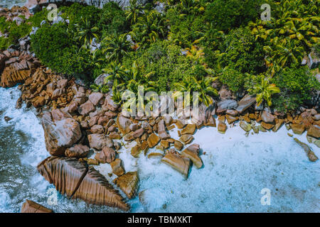 Aerial drone photo of stony boulders of beautiful Anse Cocos beach at La Digue, Seychelles Stock Photo