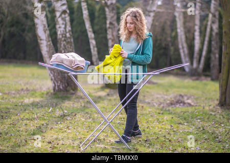 A young woman hangs the laundry in the garden Stock Photo
