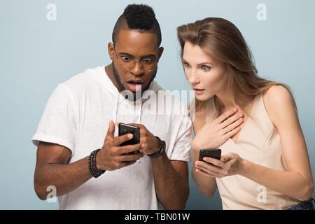 Smiling diverse people using cellphones in studio together Stock Photo