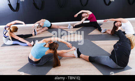 People doing the janusirsasana yoga pose while sitting in a circle – Jacob  Lund Photography Store- premium stock photo