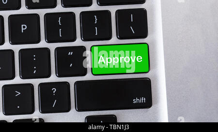 Word Approve on green button of laptop Stock Photo