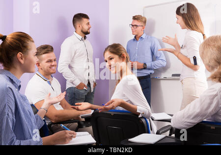 Happy young students talking with teacher and with each other on break Stock Photo