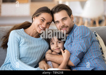 Family portrait of parents posing at home with little daughter Stock Photo