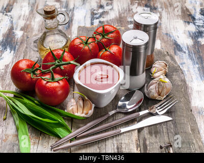 Ketchup or tomato sauce, mushrooms, garlic, spicy herbs, spices and fresh tomatoes on a branch on a rustic background. Stock Photo