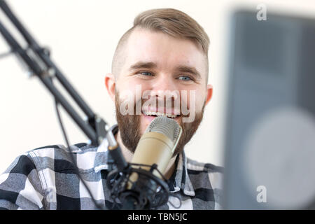Radio, dj and broadcast concept - Portrait of handsome young man with blond hair hosting show live in studio Stock Photo