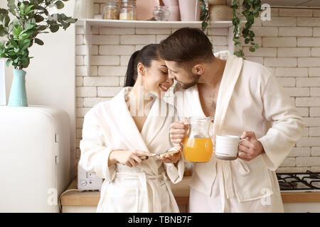 Lovely young couple having breakfast in kitchen Stock Photo