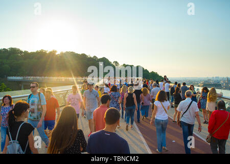 KIEV, UKRAINE - MAY 31, 2019:  Crowd of people at new Pedestrian-Bicycle Bridge at sunset. New Klitschko Pedestrian-Bicycle Bridge one of the most int Stock Photo