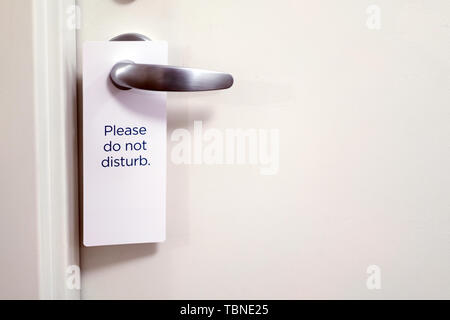 Closed door of hotel room with please do not disturb sign Stock Photo