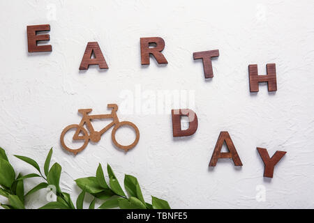 Text EARTH DAY with shape of bicycle on white background Stock Photo