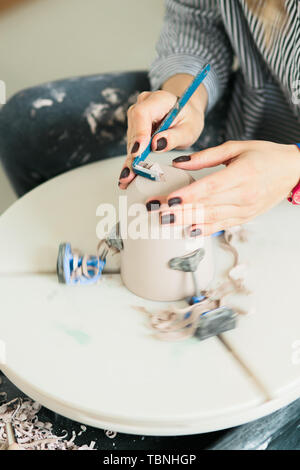 ceramic mug made on a Potter's wheel in the studio. Workshop on modeling on the potter's wheel. Stock Photo