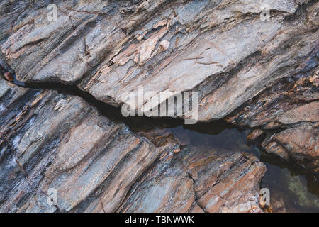 Texture of strange boulder rocks dark nook and warm color with sun lighting. Stock Photo