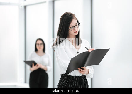 businesswoman reading a business document, standing in the office hall. photo with copy space Stock Photo