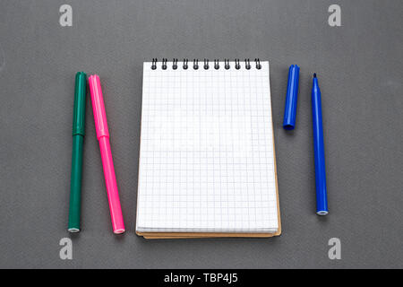 Spiral Notepad is open on a blank page. near there are colored markers. space for text Stock Photo