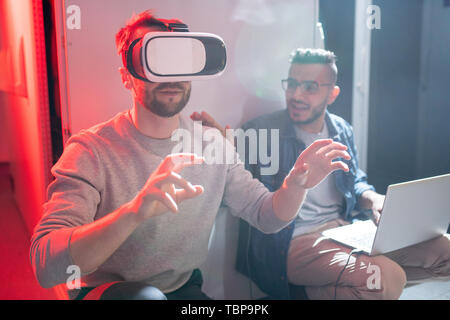 Startup IT engineers using virtual reality simulator while studying options of modern technology in innovative scientific lab Stock Photo